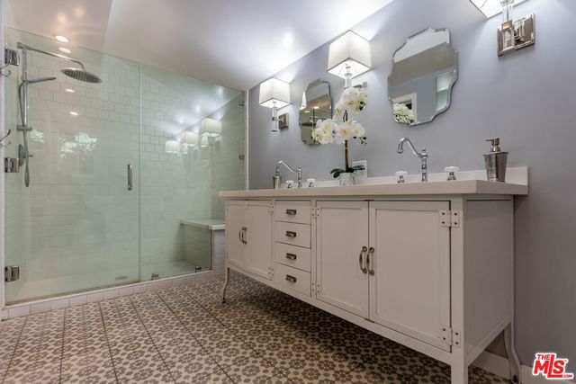 a bathroom with a sink a mirror and a shower
