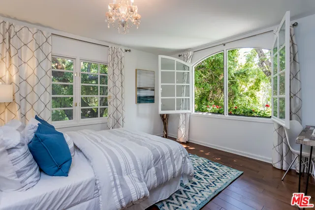 a bedroom with a large bed and a large window