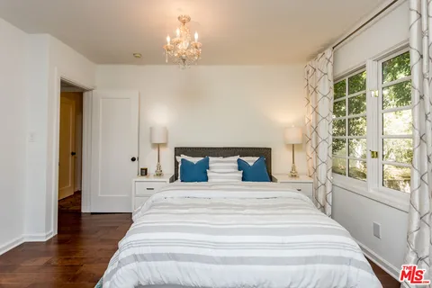 a spacious bedroom with a large bed and a chandelier