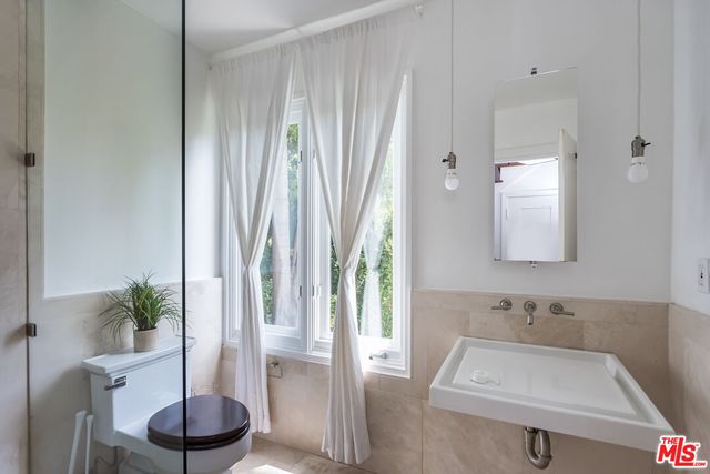 a bathroom with a sink a toilet and a mirror