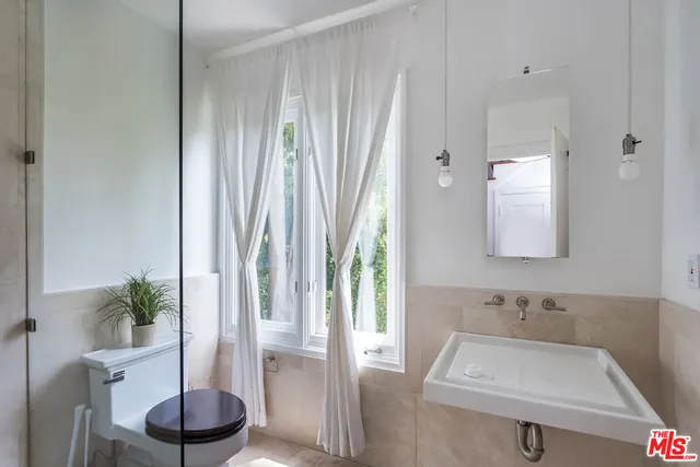 a bathroom with a sink a toilet and a mirror