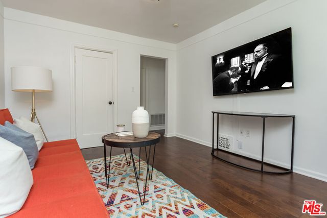 a living room with furniture and a painting on the wall