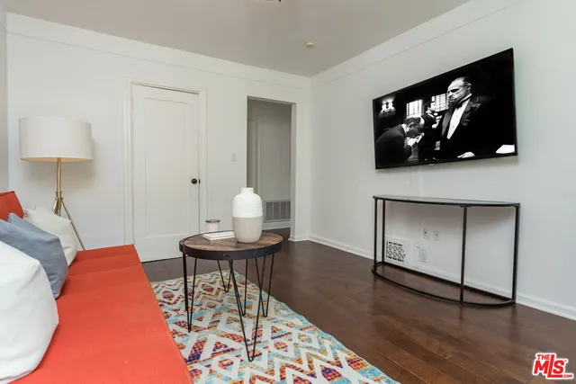 a living room with furniture and a painting on the wall