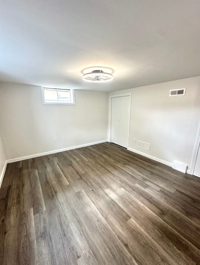 906 West Walnut Street Kankakee, IL 60901 - Photo 11 of 14 an empty room with wooden floor and windows