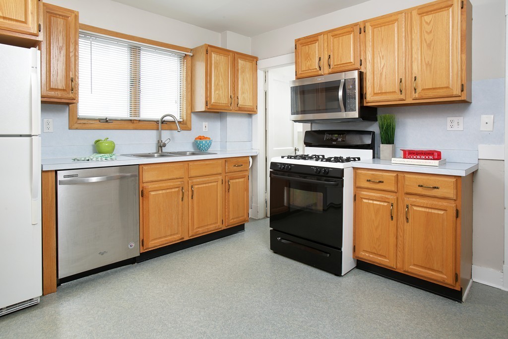 517 Heath Street Brookline, MA 02467 - Photo 5 of 12 a kitchen with cabinets appliances a sink and a window