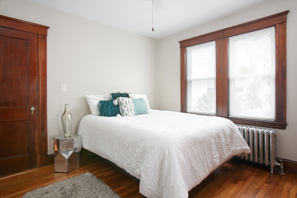 517 Heath Street Brookline, MA 02467 - Photo 7 of 12 a bedroom with a bed and wooden floor