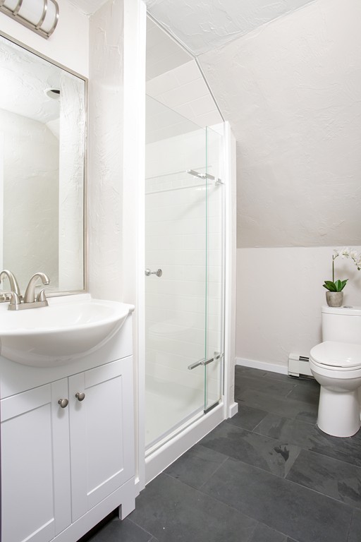 517 Heath Street Brookline, MA 02467 - Photo 10 of 12 a bathroom with a sink a toilet and shower