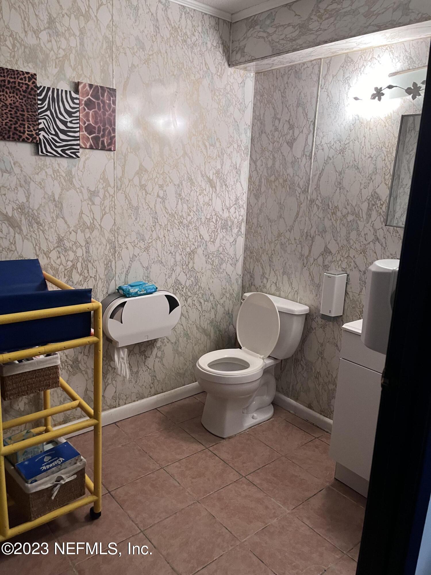 10367 Monaco Drive Jacksonville, FL 32218 - Photo 46 of 49 a white toilet sitting next to a shower curtain