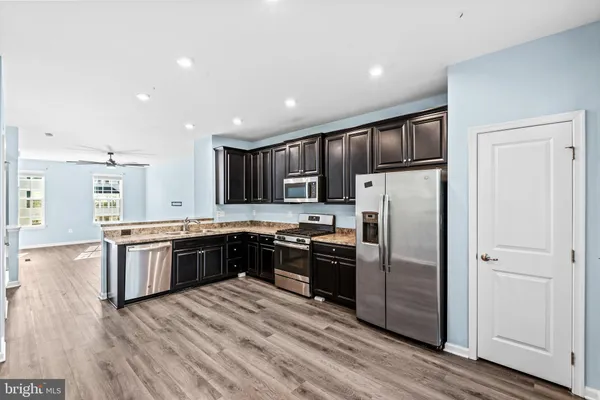 a kitchen with granite countertop stainless steel appliances and wooden cabinets