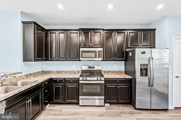 a kitchen with granite countertop a stove and a refrigerator
