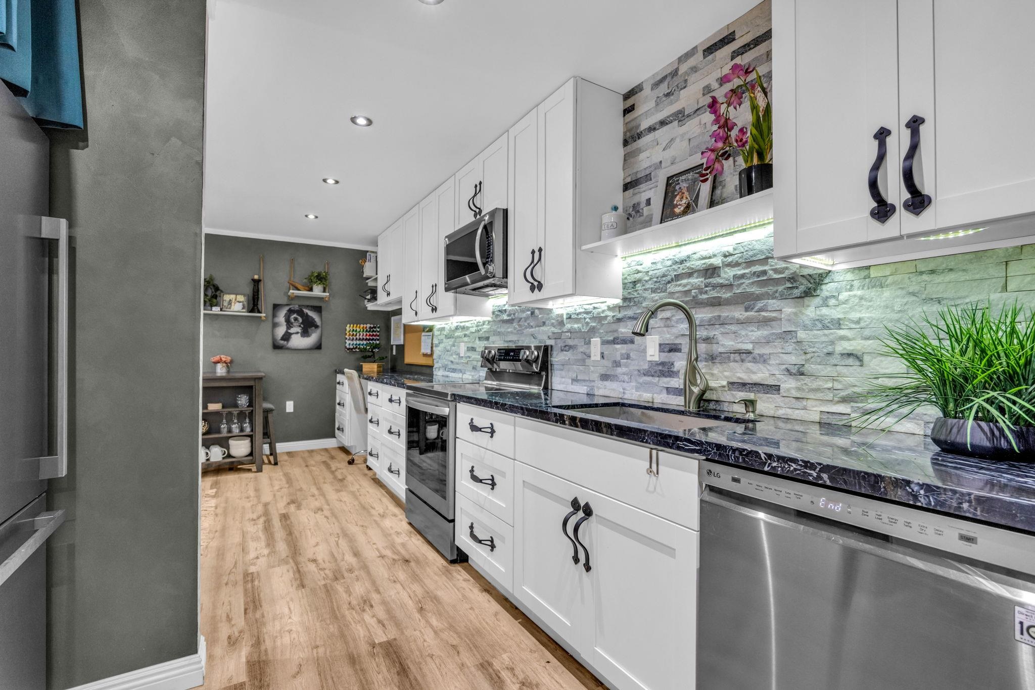 160 Keonekai Road, Unit 13102 Kihei, HI 96753 - Photo 5 of 36 a kitchen with stainless steel appliances granite countertop a sink and wooden cabinets