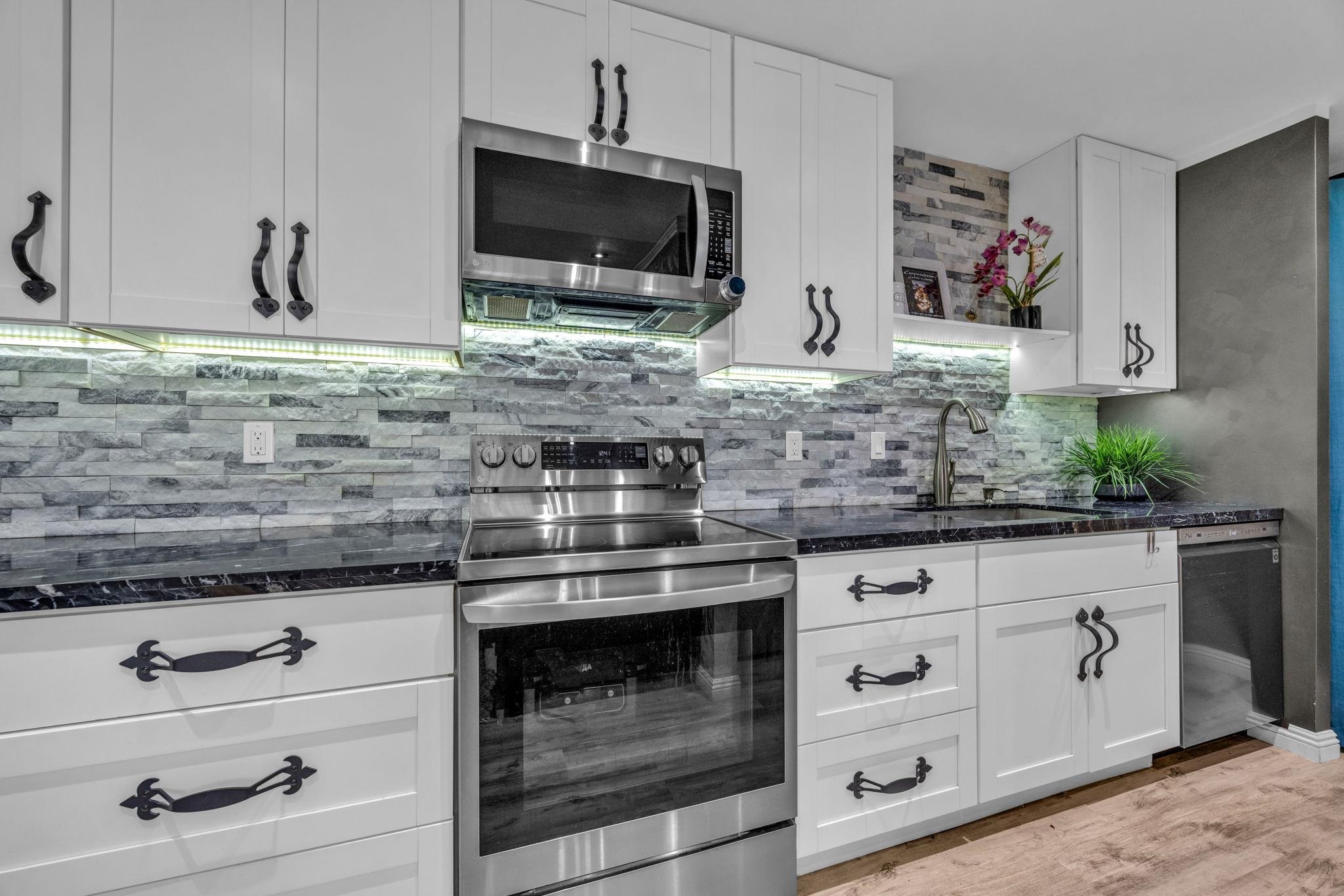 160 Keonekai Road, Unit 13102 Kihei, HI 96753 - Photo 6 of 36 a kitchen with granite countertop white cabinets stainless steel appliances and a counter space