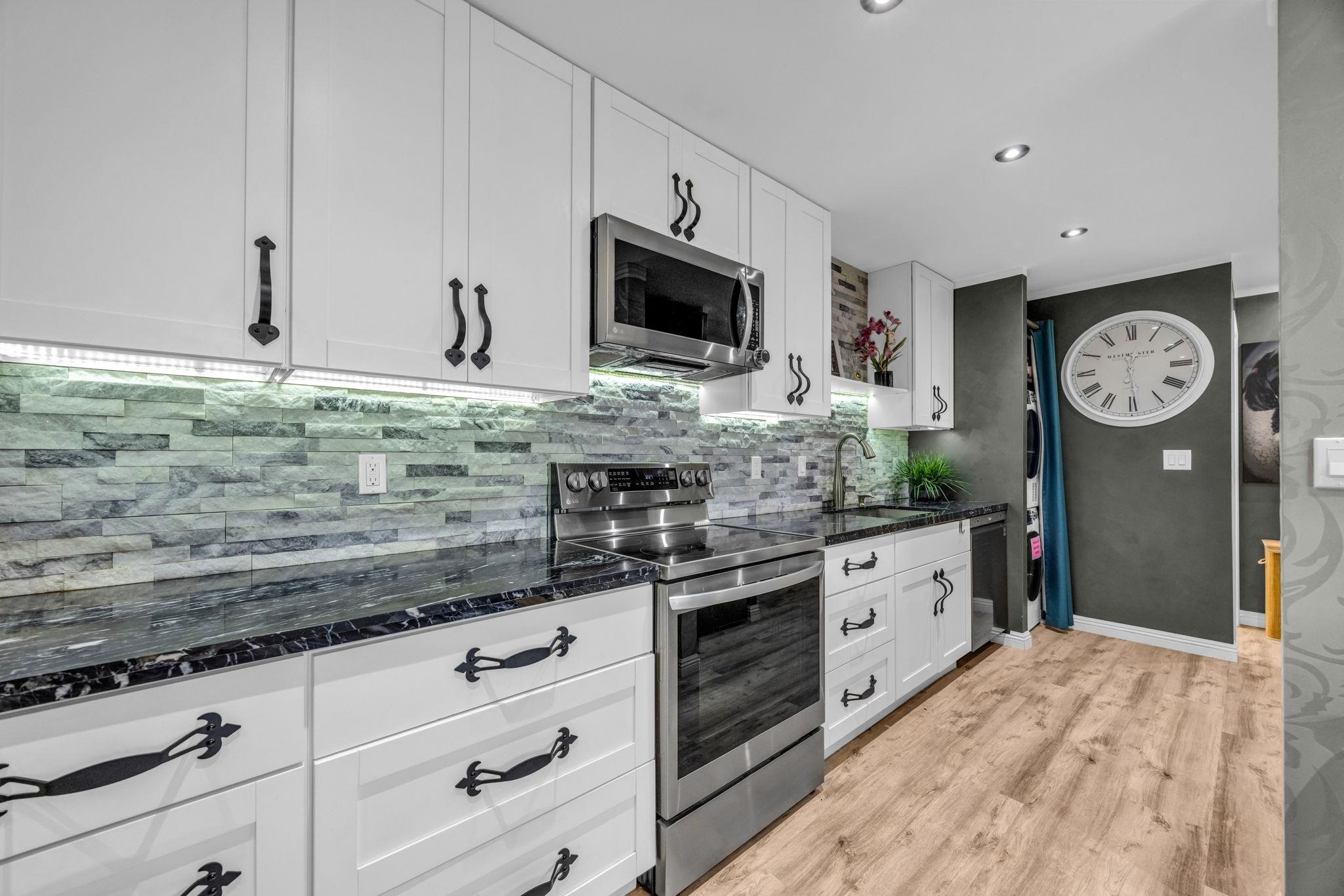 160 Keonekai Road, Unit 13102 Kihei, HI 96753 - Photo 8 of 36 a kitchen with stainless steel appliances granite countertop a stove a sink and a microwave