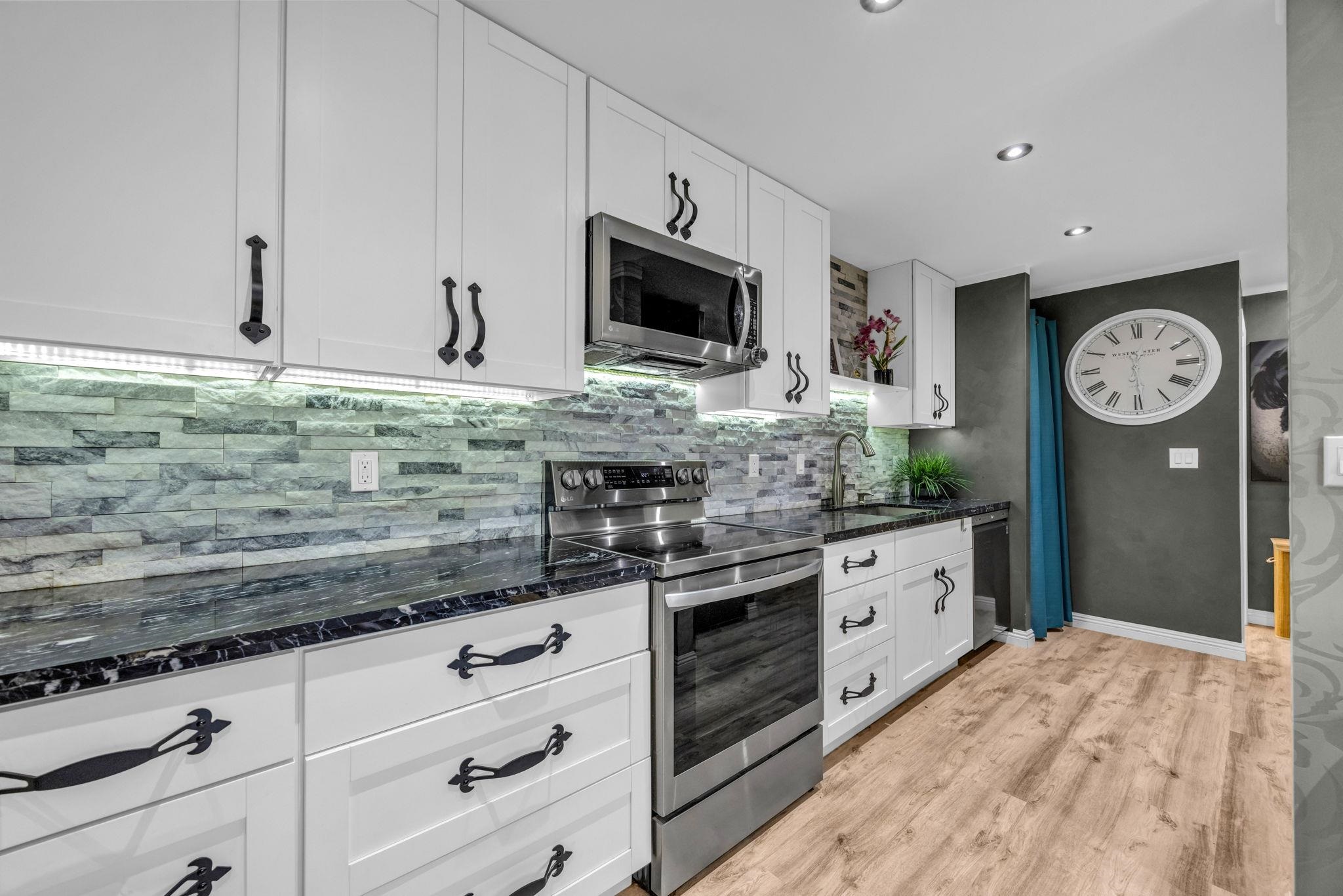 160 Keonekai Road, Unit 13102 Kihei, HI 96753 - Photo 9 of 36 a kitchen with stainless steel appliances granite countertop a stove a sink and a microwave