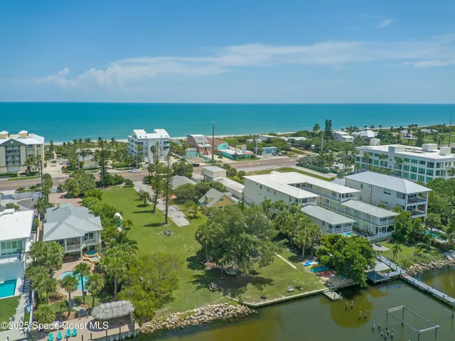 an aerial view of a house with a yard and lake view