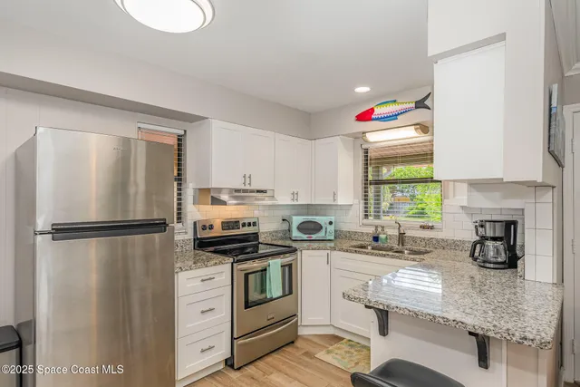 a utility room with dryer washer and a view of living room