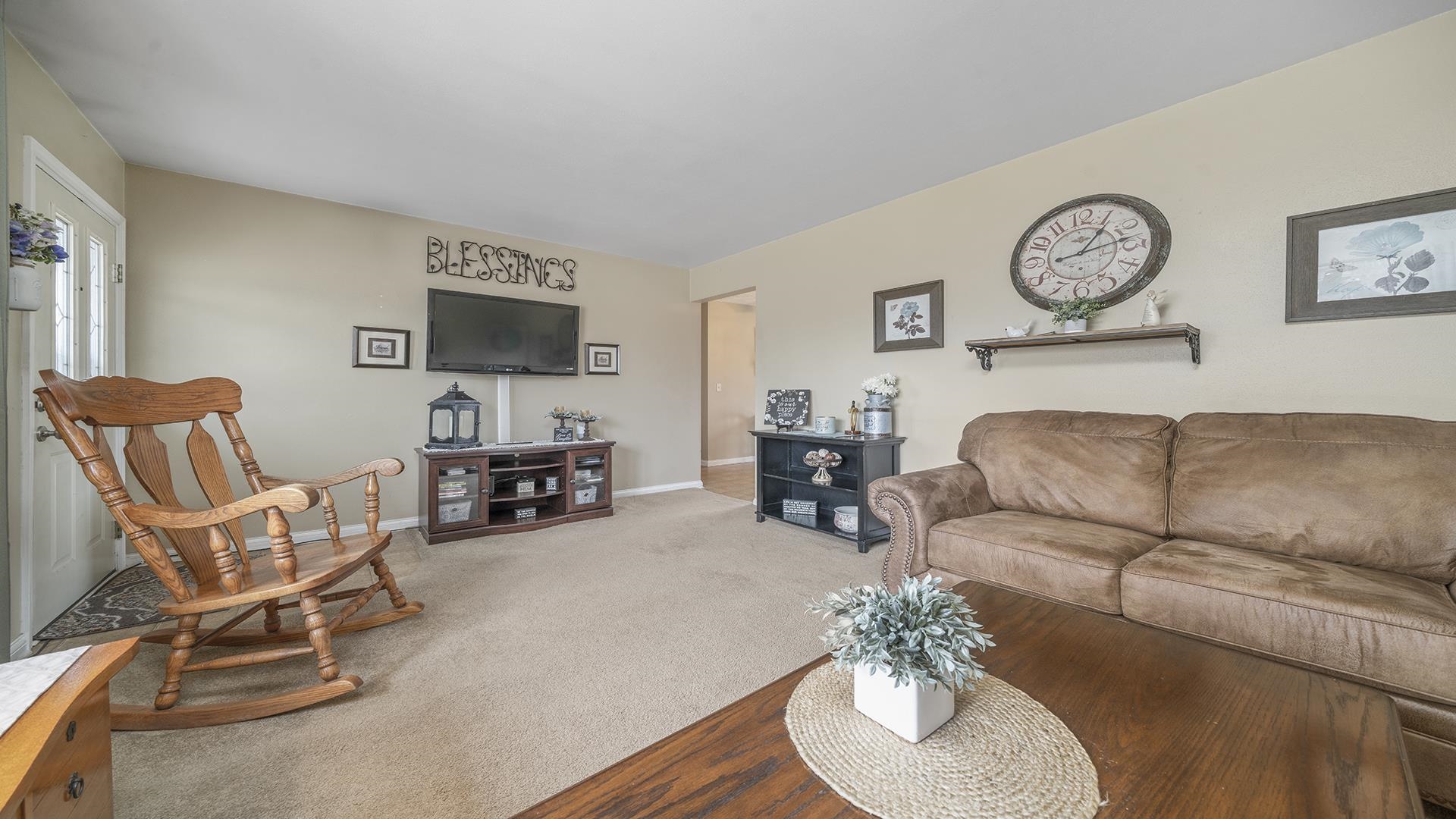 6858 Ralph Road Rockford, IL 61109 - Photo 5 of 24 a living room with furniture a clock on wall and a window