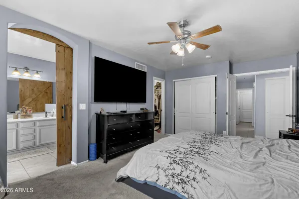 a bed sitting in a bedroom next to a window with tv