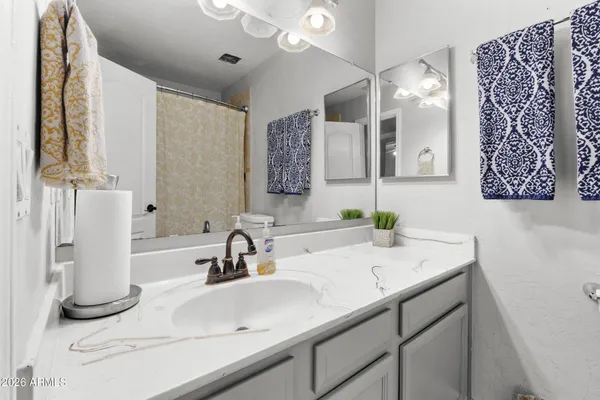 a bedroom with a bed a flat screen tv and a chandelier