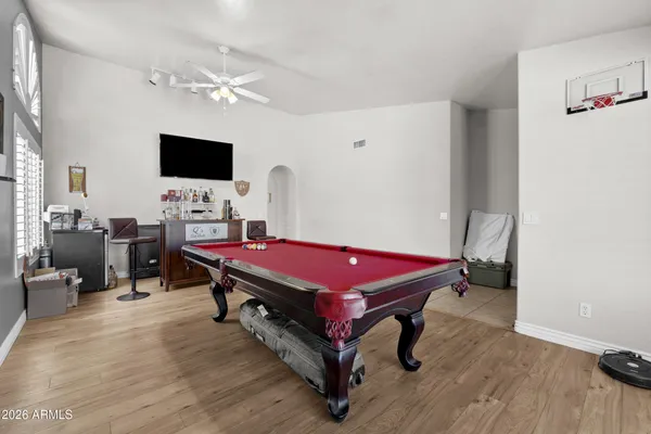 a living room with furniture a flat screen tv and a chandelier