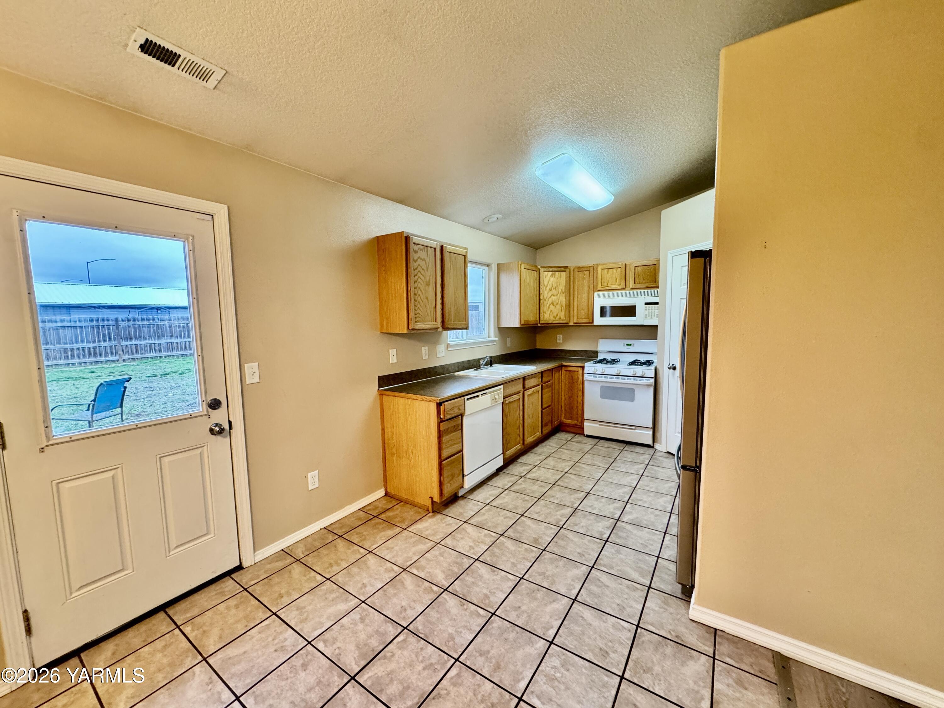 815 Jessica Court Grandview, WA 98930 - Photo 12 of 27 a kitchen with stainless steel appliances granite countertop a refrigerator and a stove top oven
