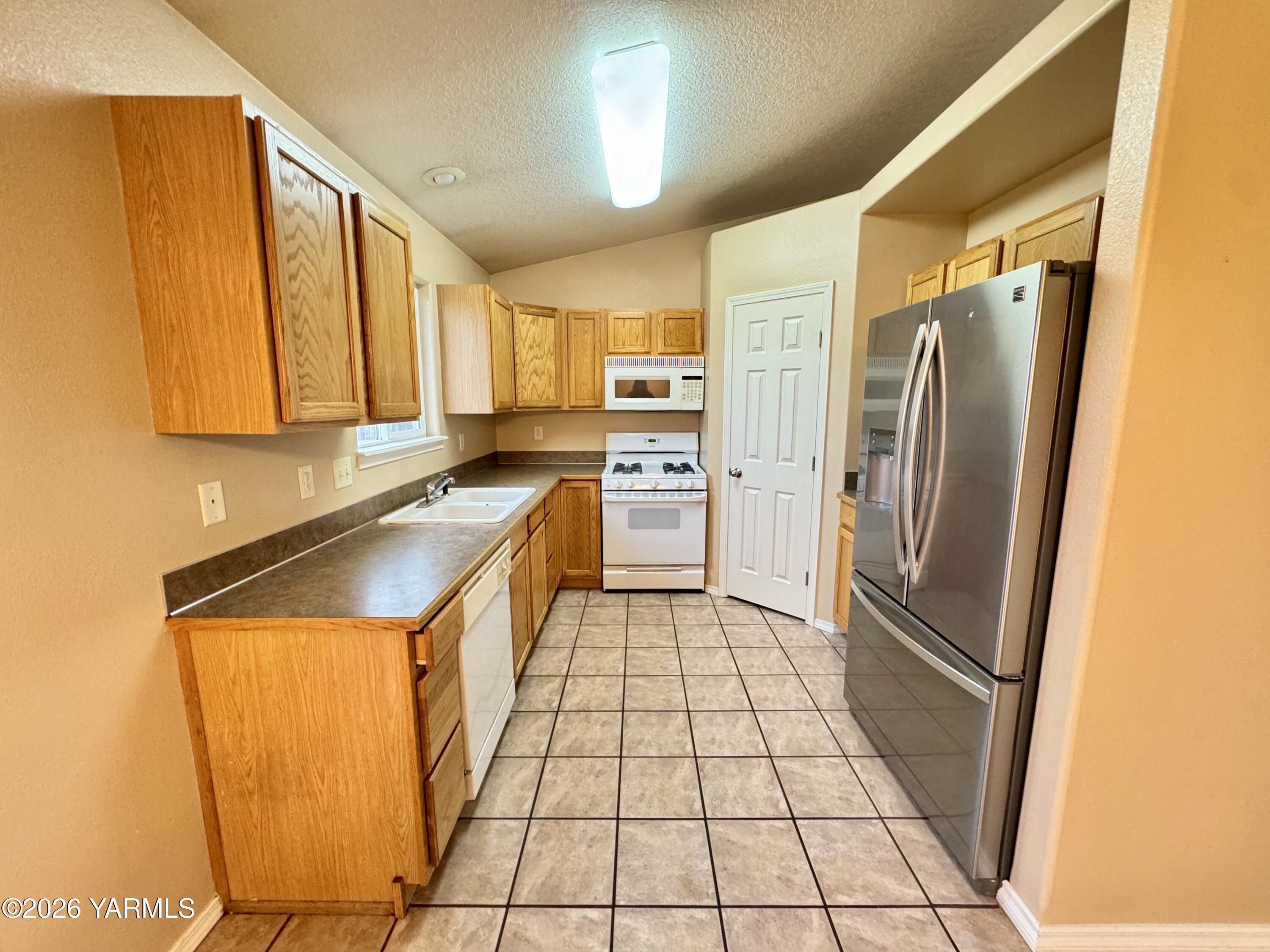815 Jessica Court Grandview, WA 98930 - Photo 13 of 27 a kitchen with a refrigerator a sink and dishwasher