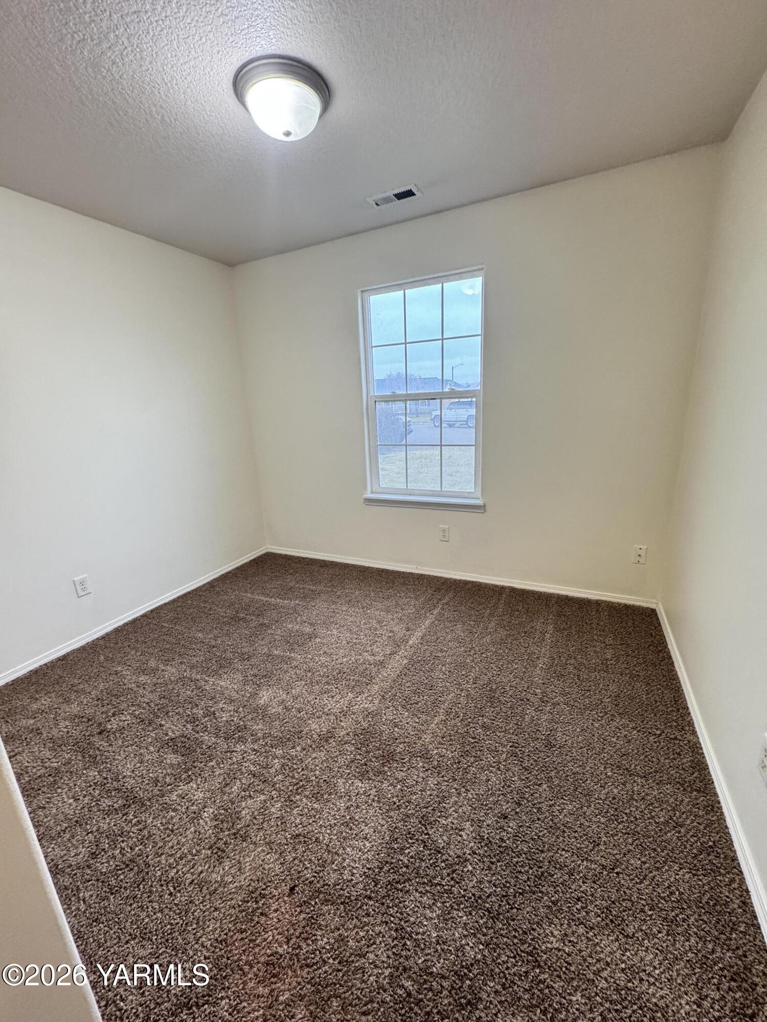 815 Jessica Court Grandview, WA 98930 - Photo 23 of 27 an empty room with a empty space and windows