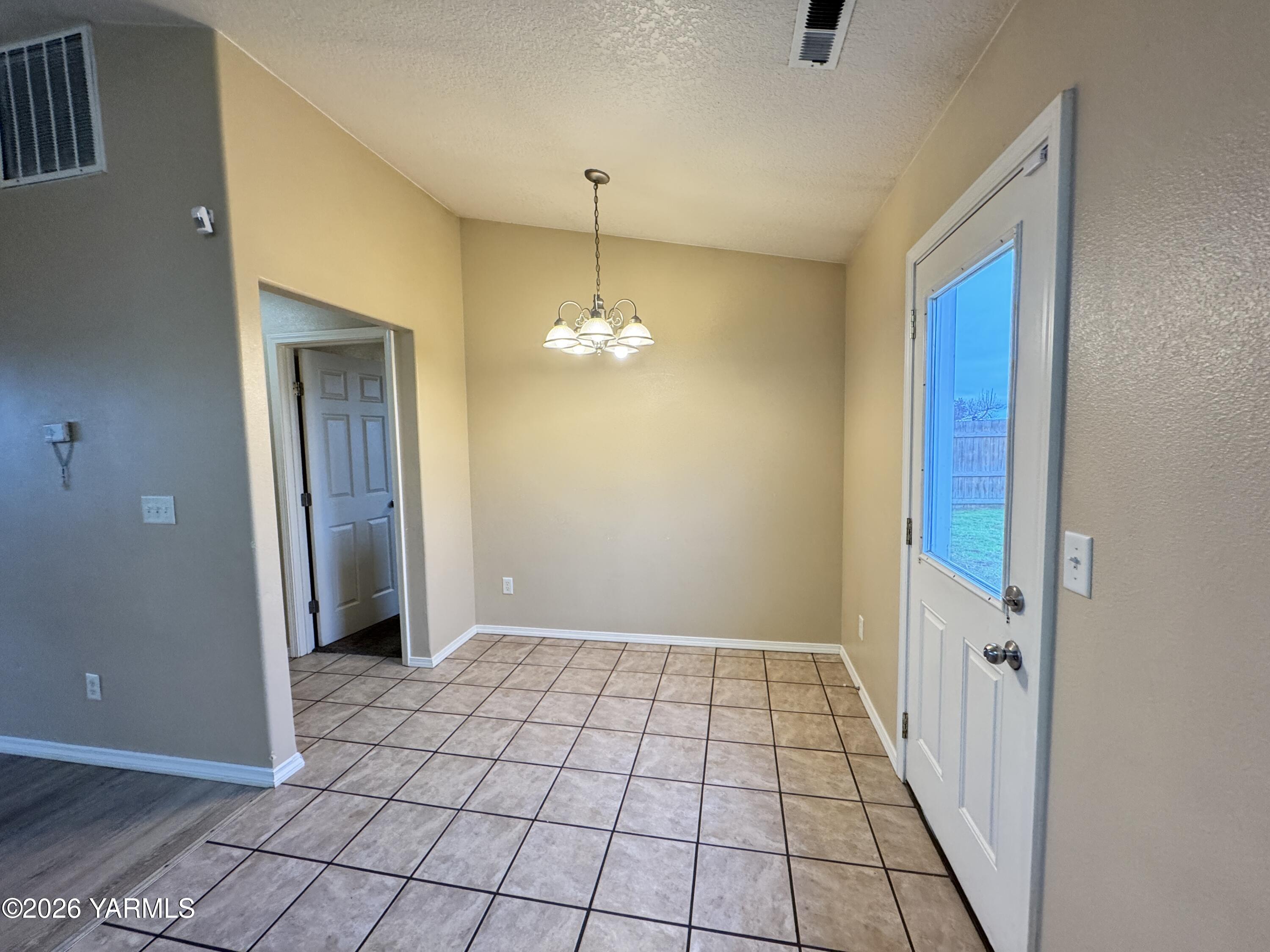 815 Jessica Court Grandview, WA 98930 - Photo 10 of 27 a view of a hallway with a chandelier