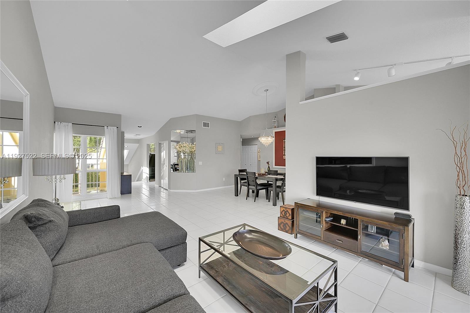 17317 Boca Club Boulevard, Unit 7 Boca Raton, FL 33487 - Photo 13 of 48 a living room with furniture and a flat screen tv