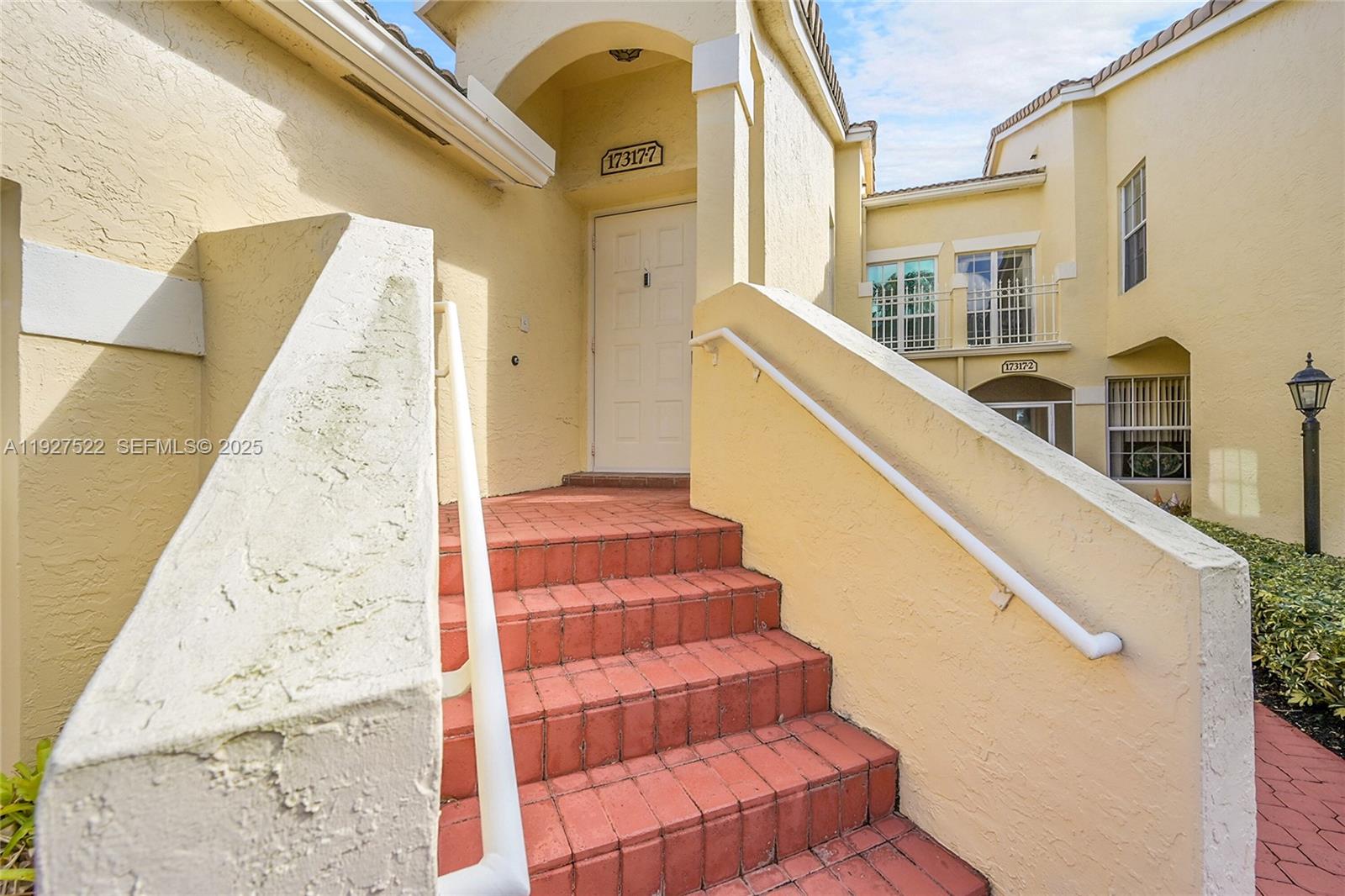 17317 Boca Club Boulevard, Unit 7 Boca Raton, FL 33487 - Photo 4 of 48 a view of staircase with lots of frames on wall and a potted plant