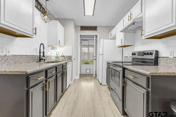 a kitchen with stainless steel appliances granite countertop a sink stove and cabinets