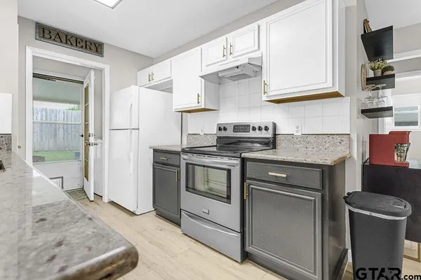 a kitchen with stainless steel appliances granite countertop a refrigerator stove and sink