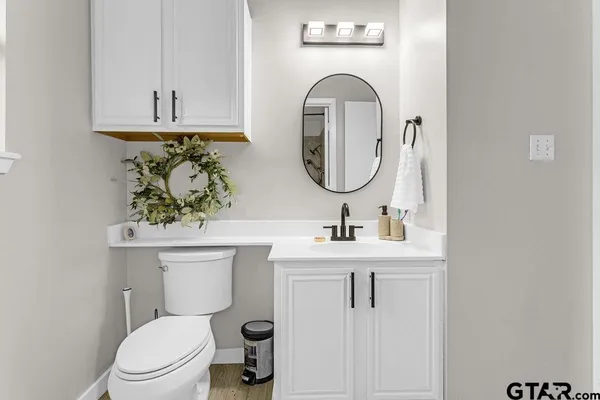 a bathroom with a toilet sink and mirror
