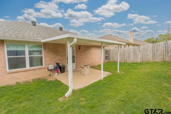 a view of a backyard with table and chairs and wooden fence
