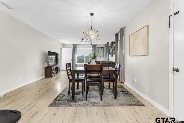 a dining room with furniture a chandelier and wooden floor