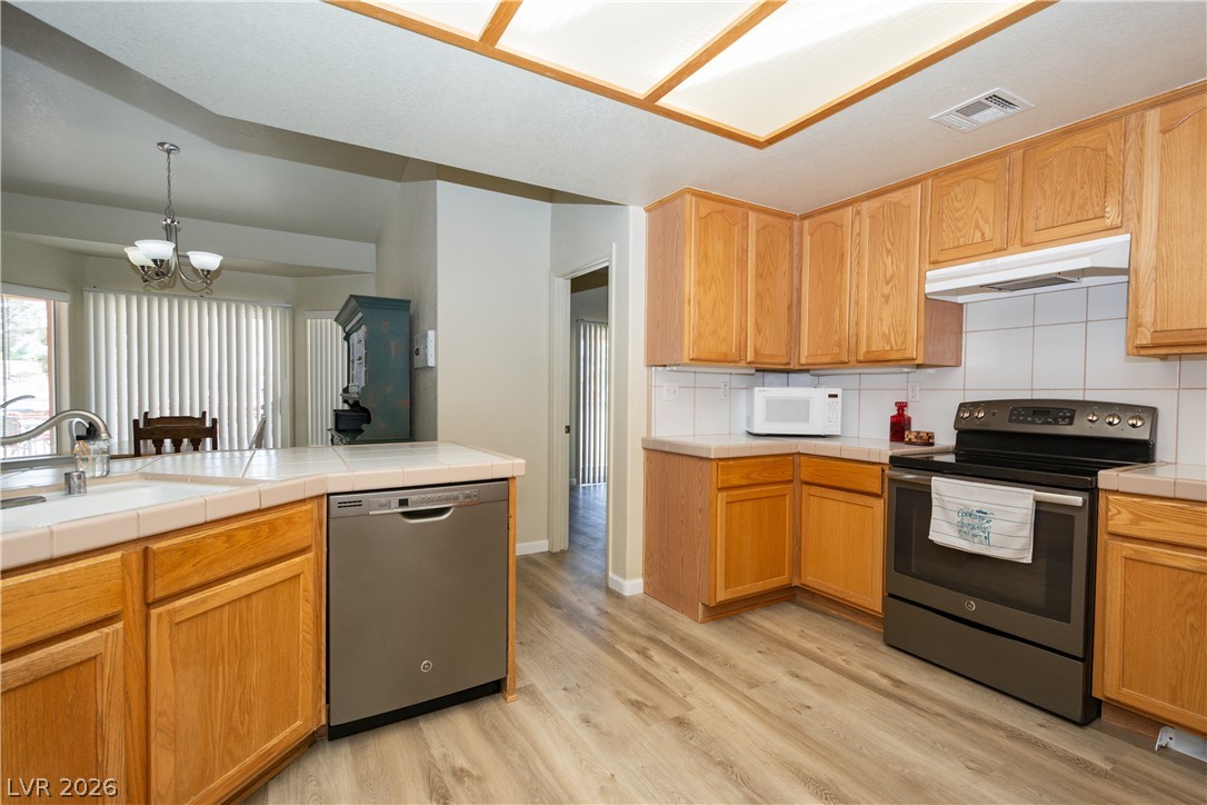 2381 Tough Boy Road Pahrump, NV 89060 - Photo 10 of 44 This bright kitchen features wood cabinetry and essential appliances, perfect for daily living.