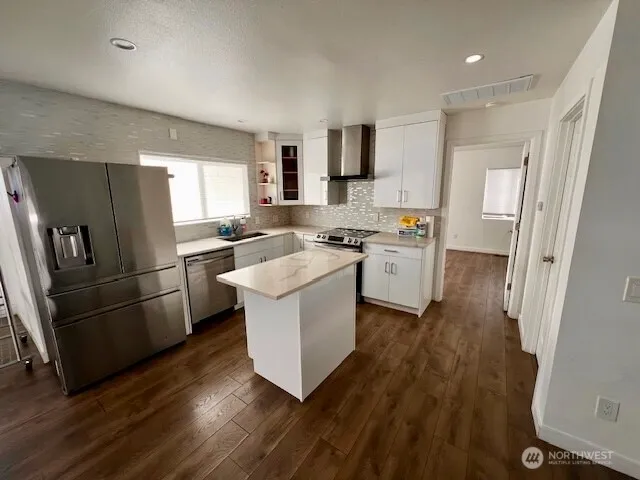 a kitchen with a sink a refrigerator a stove top oven and wooden floor
