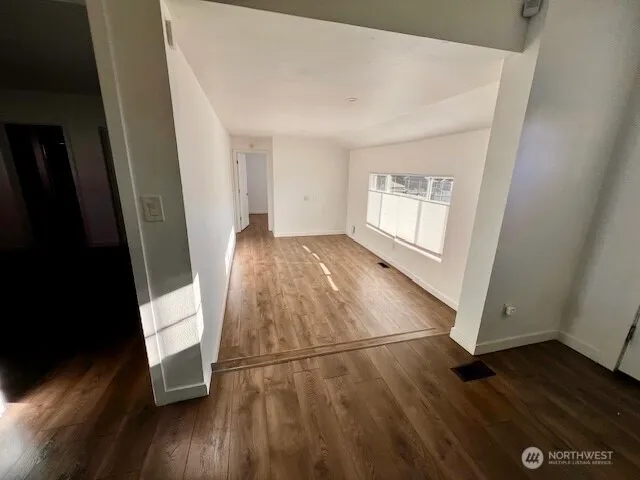 a view of a room with wooden floor and a window