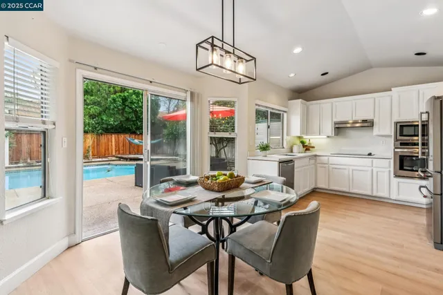 a dining room with furniture a chandelier and wooden floor
