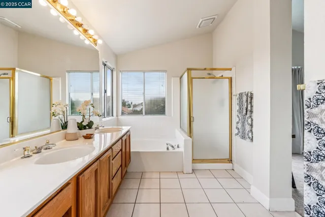 an empty room with chandelier fan and windows