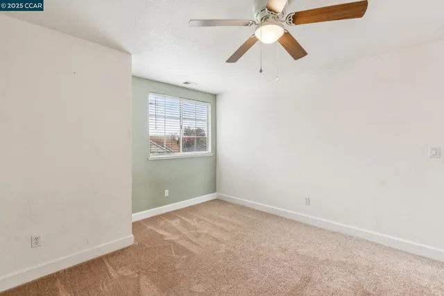 a view of a livingroom with a ceiling fan and entryway