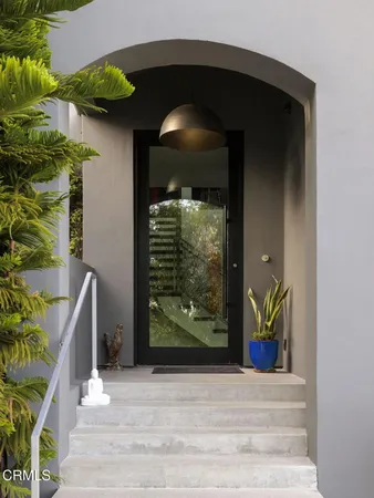 a view of an entryway door with potted plants