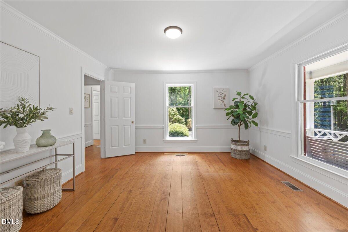6516 Bakersfield Drive Raleigh, NC 27606 - Photo 24 of 59 a view of an empty room with wooden floor and a window