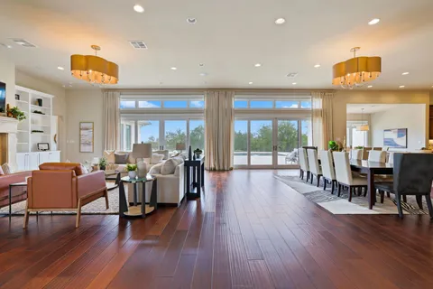a living room with furniture and wooden floor next to a large window