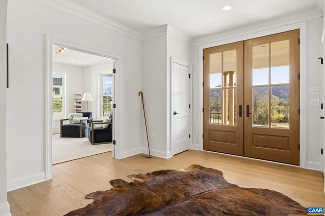 a living room with furniture a chandelier and a large window