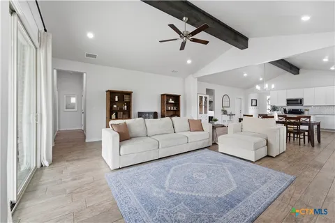 a living room with furniture and a view of kitchen