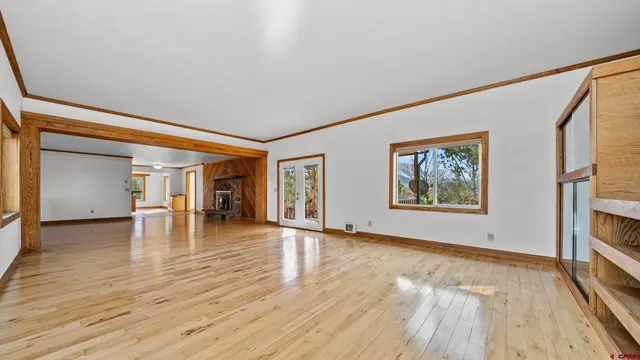 a view of empty room with wooden floor and fireplace