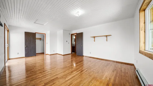 a view of a hallway with wooden floor and a hallway