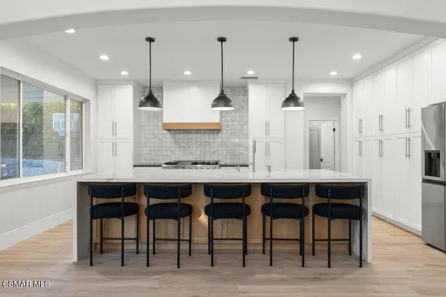 a kitchen with a table chairs refrigerator and microwave