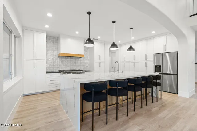 a kitchen with stainless steel appliances granite countertop sink refrigerator and cabinets